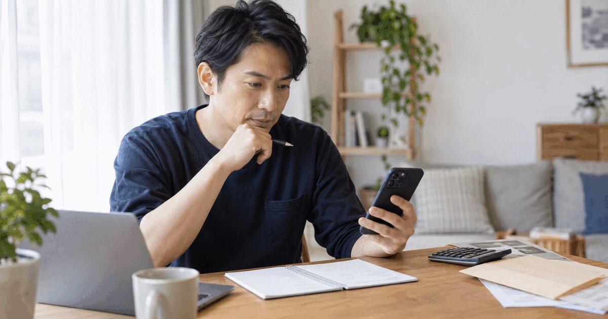 親和クリニックの相談前にスマホを見ながら質問メモを準備する男性